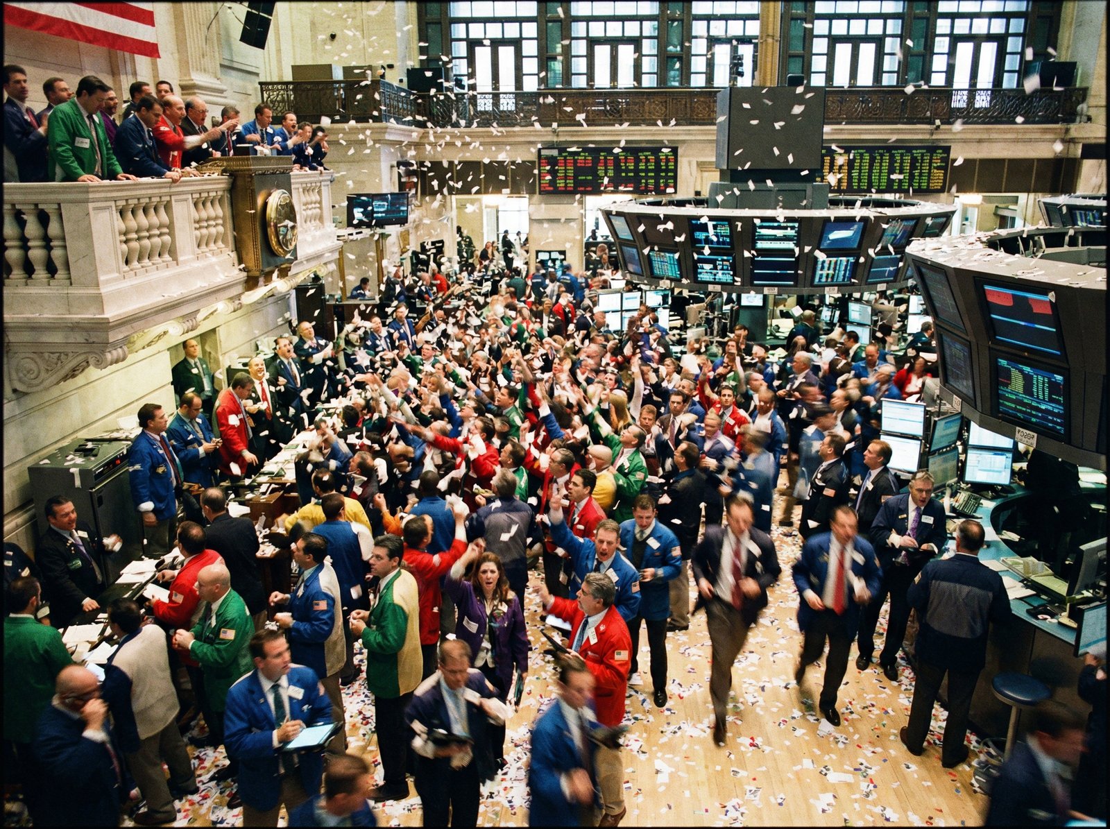 A wide shot of the bustling trading floor of the New York Stock Exchange, with traders actively working. The scene should convey a sense of energy and movement. Aspect ratio 4:3, no visible text.