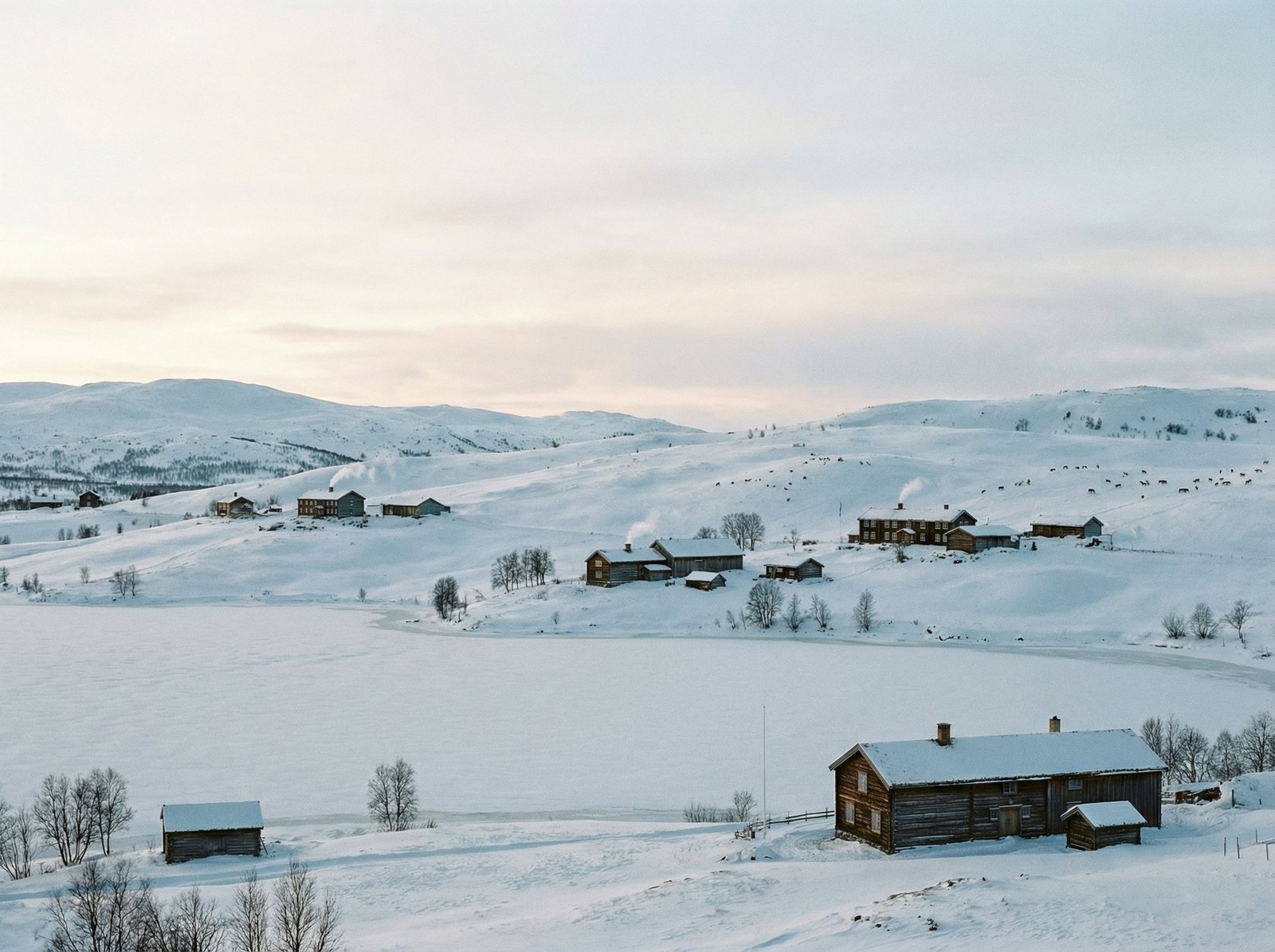 A serene winter landscape in the Røros Circumference area, with snow-covered rolling hills, scattered traditional farms, and a frozen lake under a soft, diffused light. Remote and peaceful atmosphere. Aspect ratio 4:3, no visible text.