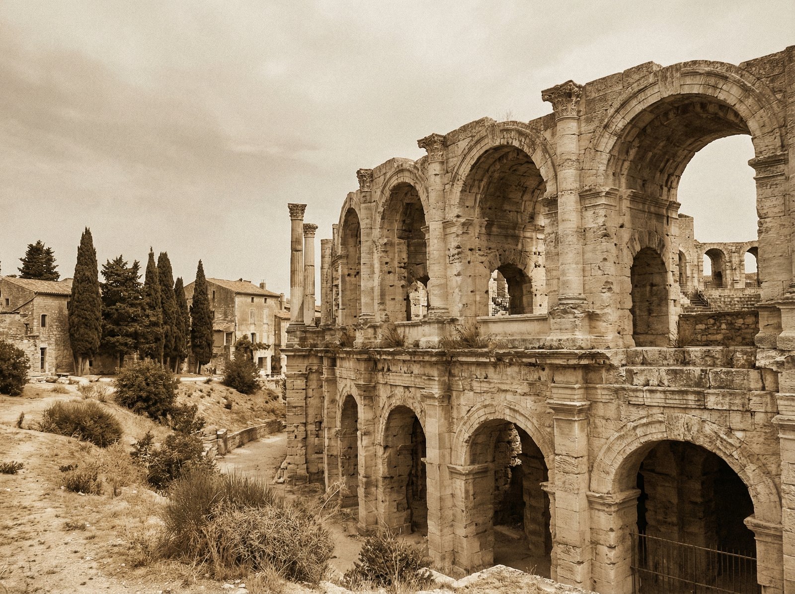 Ancient Roman theater ruins in Arles, France, with sparse columns standing against a historical setting, history style, aspect ratio 4:3, no visible text