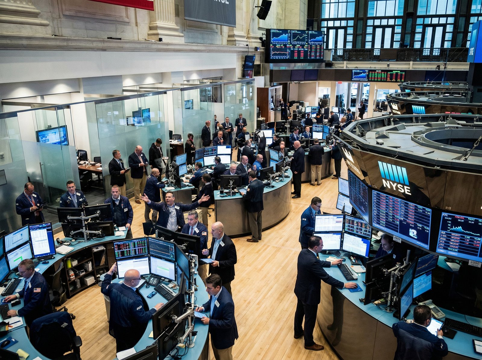 A busy trading floor at the New York Stock Exchange, traders looking at multiple screens with financial data, bright and balanced lighting, modern layout, high contrast. 4:3 aspect ratio, no visible text.