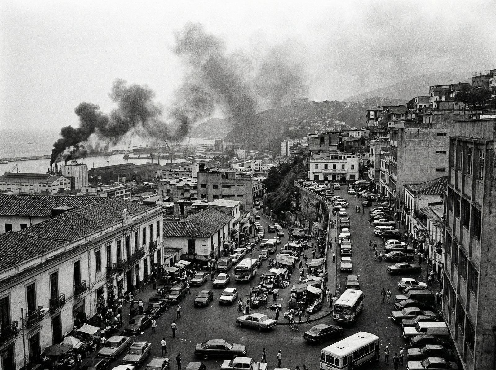 Smoke rising from the Port of La Guaira in Caracas, Venezuela, with a chaotic street scene below. Urban landscape, dramatic, high contrast, no visible text, 4:3 aspect ratio.