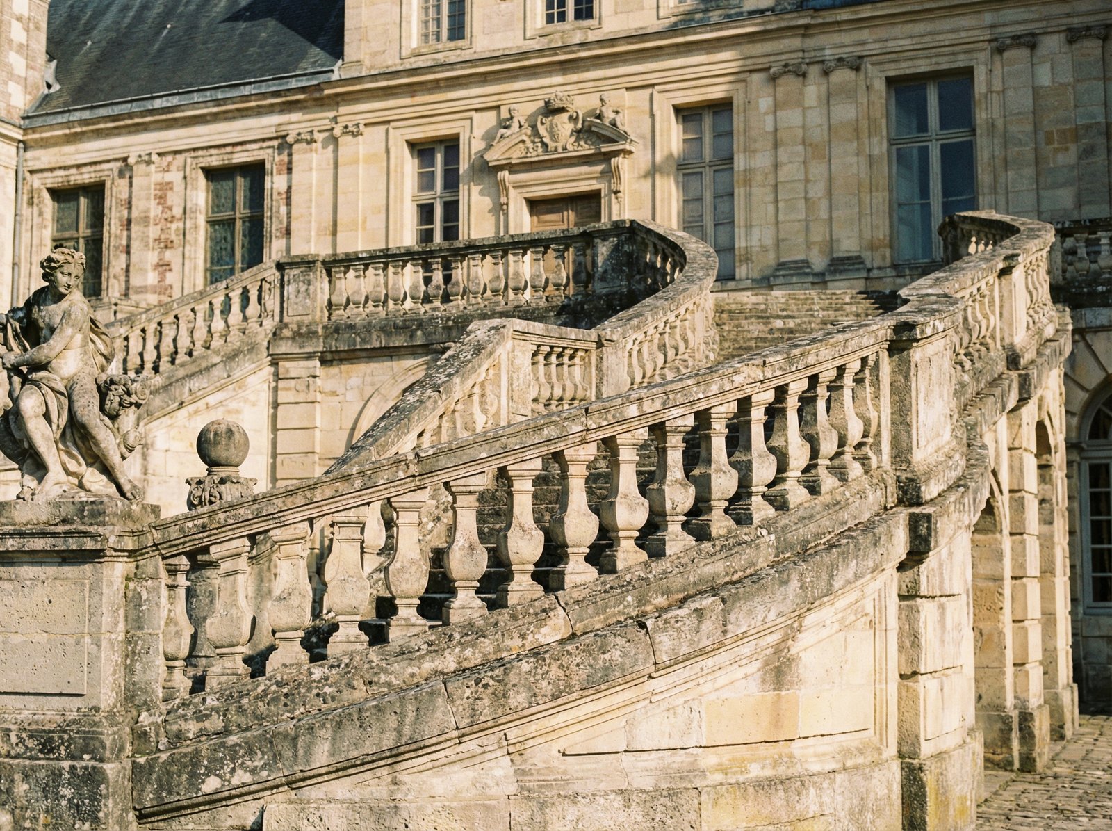 Close-up of the iconic horseshoe-shaped staircase at Fontainebleau Palace, intricate stone masonry, historical atmosphere, sunny day, 4:3, no text