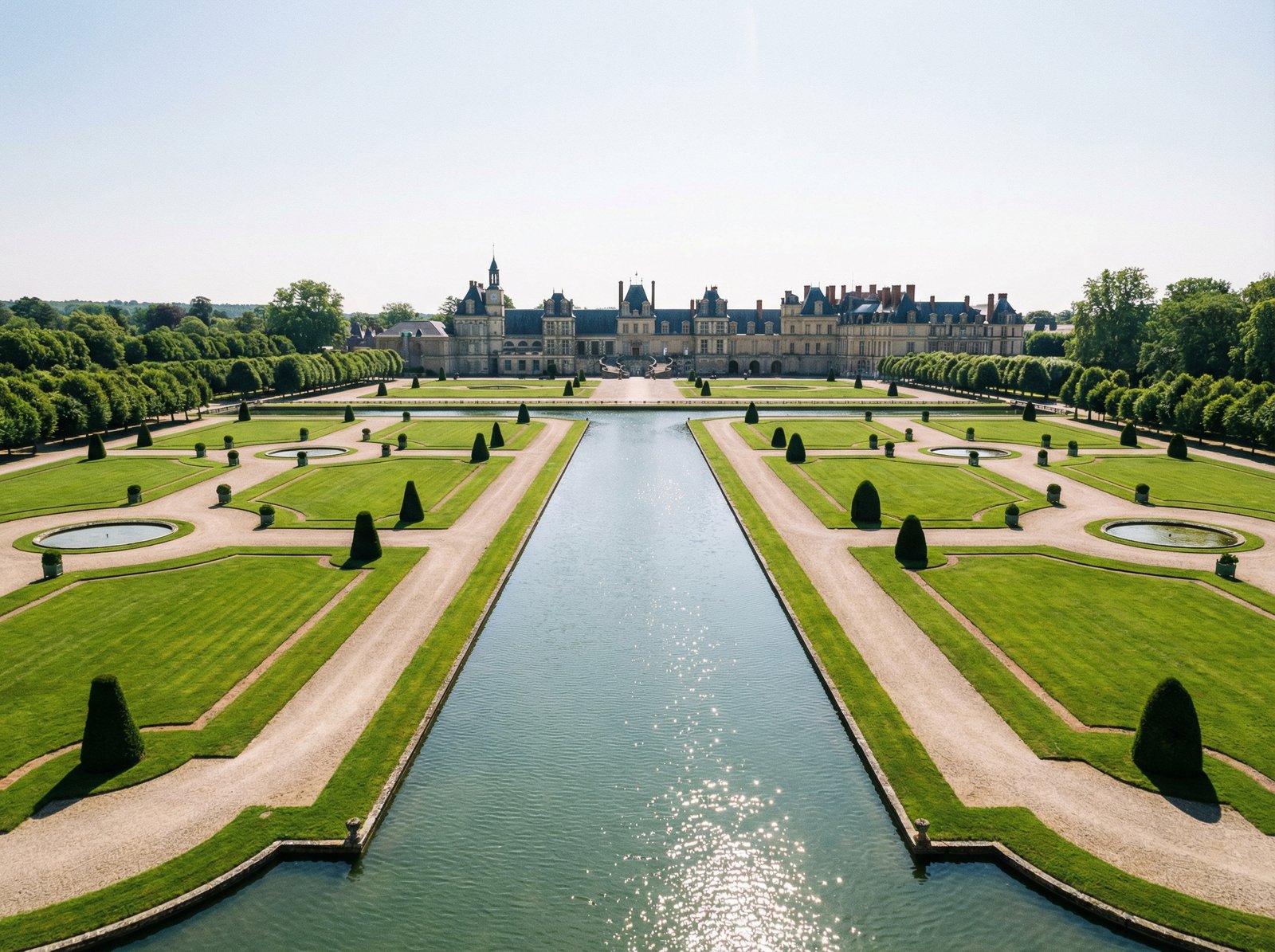 Panoramic view of the Grand Canal and formal gardens at Fontainebleau, symmetrical landscaping, lush green grass, palace in the distance, 4:3, no text