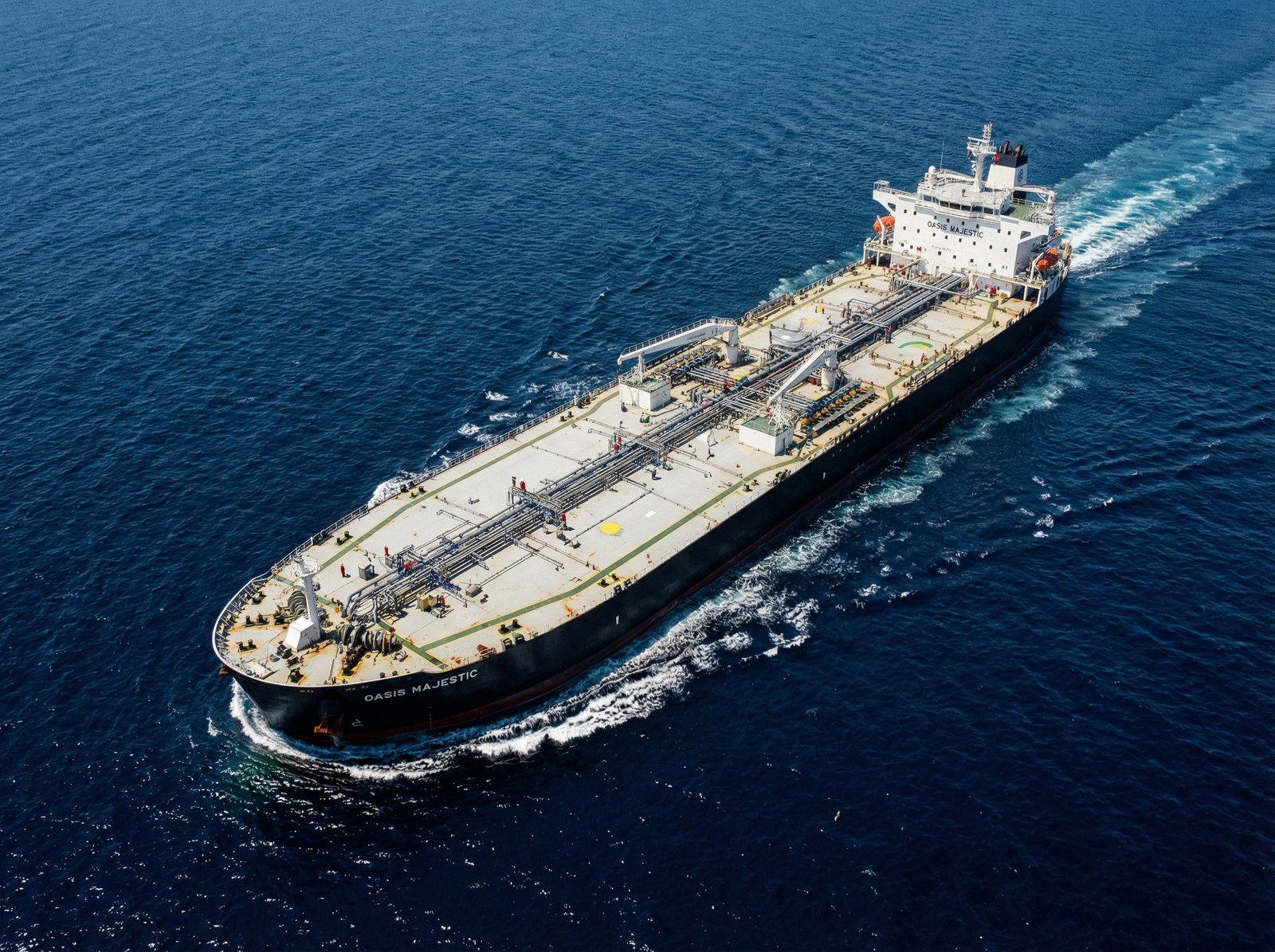 A massive oil tanker sailing across a deep blue ocean during a clear day, detailed composition of the ship and sea, aerial view, realistic style, 4:3, no text