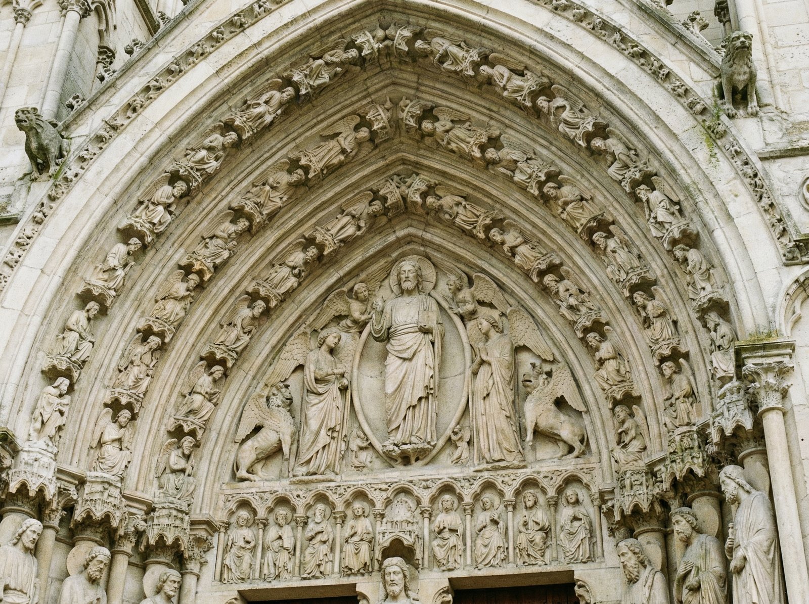 Close-up of intricate stone carvings on the facade of Amiens Cathedral, showing detailed biblical figures and decorative elements. Style: History/Culture, Aspect ratio: 4:3, no visible text.