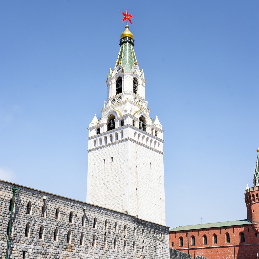 Ivan the Great Bell Tower in the Kremlin Moscow, tall white stone tower with golden dome and red star, bright daylight, textured background, aspect ratio 1:1