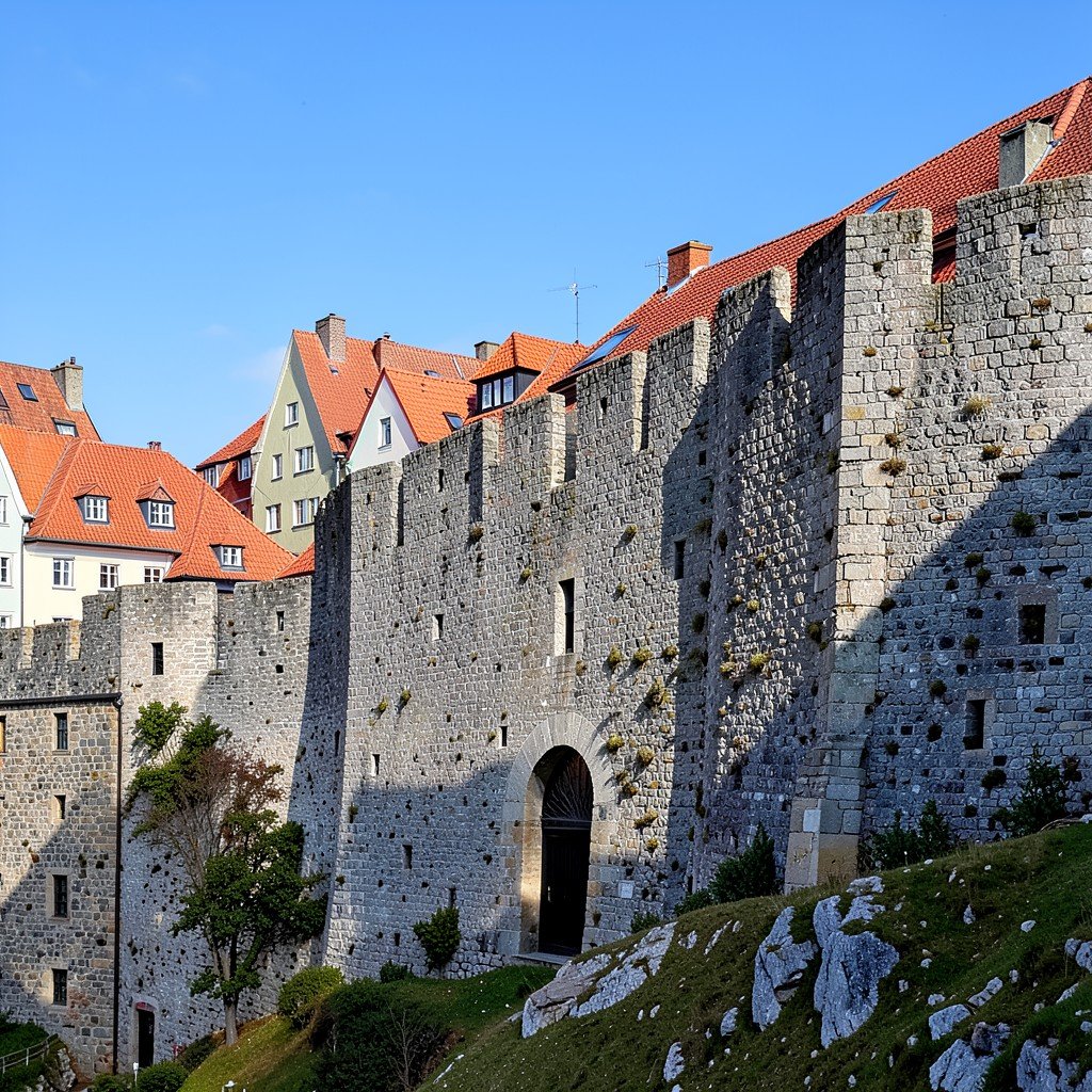 Ancient medieval stone wall of Visby Sweden with surrounding red roofed houses and blue sky natural lighting no text aspect ratio 1:1